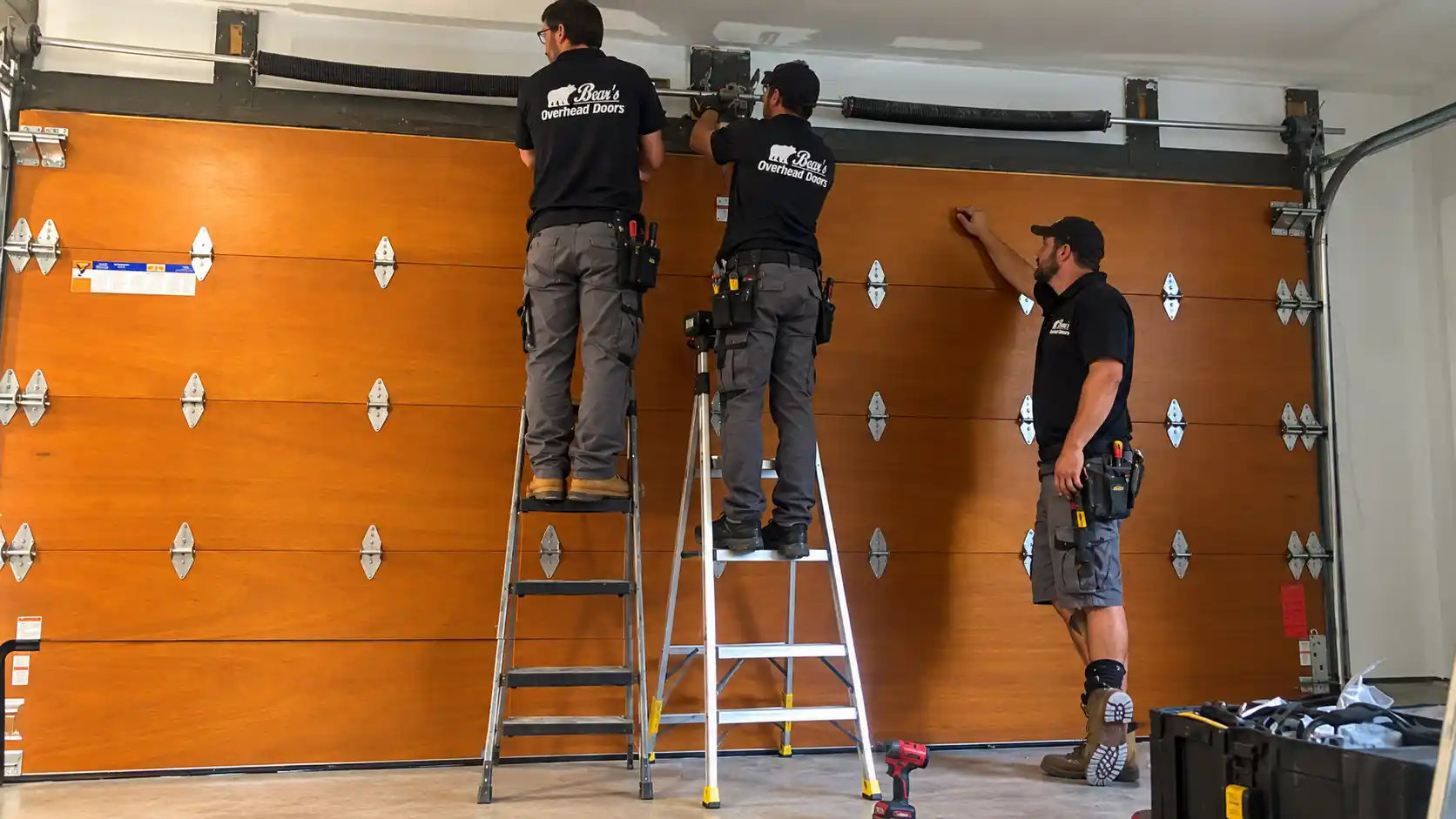 Bear's Overhead Doors technician servicing a residential garage door
